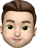Ein Memoji-Charakter mit gestyltem braunem Haar, grünen Augen und hellem Bart, der schwarze Ohrstecker trägt.