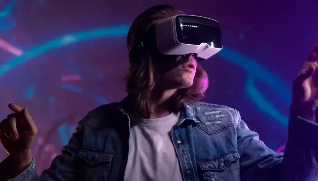 Eine Frau in einer Jeansjacke, die ein VR-Headset trägt.