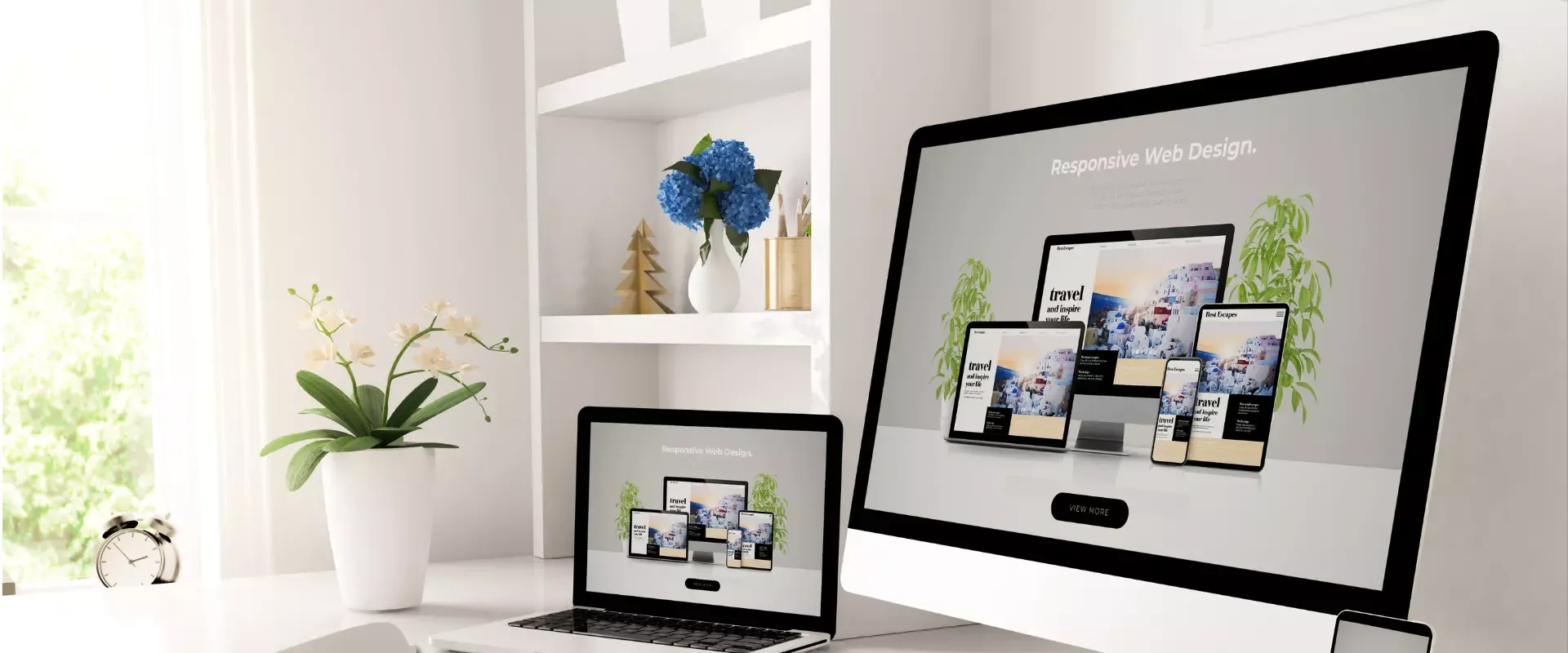 Ein Laptop und ein Desktop-Monitor zeigen ein Webdesign-Konzept in einem hellen, modernen Arbeitsbereich.