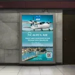 Werbeplakat der Alpenair mit einem Flugzeug des Typs Tecnam P2012 Traveller, das für Flüge über den Bodensee wirbt und in einer U-Bahn-Station hängt.