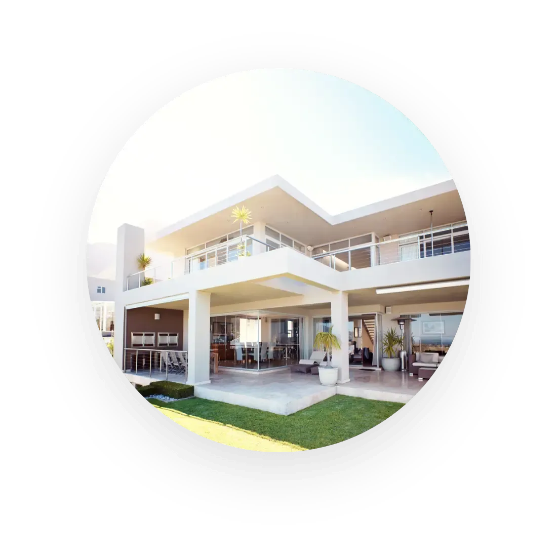 Modernes zweistöckiges Haus mit großen Fenstern, Balkonen und einer Terrasse im Hinterhof, von außen an einem sonnigen Tag betrachtet.