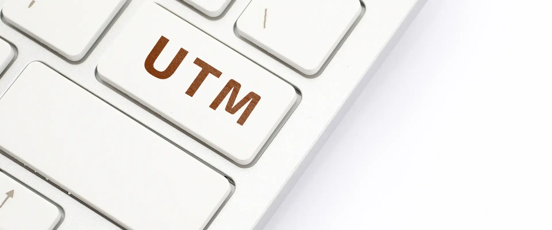 Nahaufnahme einer Computertastatur mit einer Taste mit der Aufschrift „UTM“ in braunen Buchstaben, perfekt für alle, die sich mit URL-Tracking und Google Analytics 4 befassen.