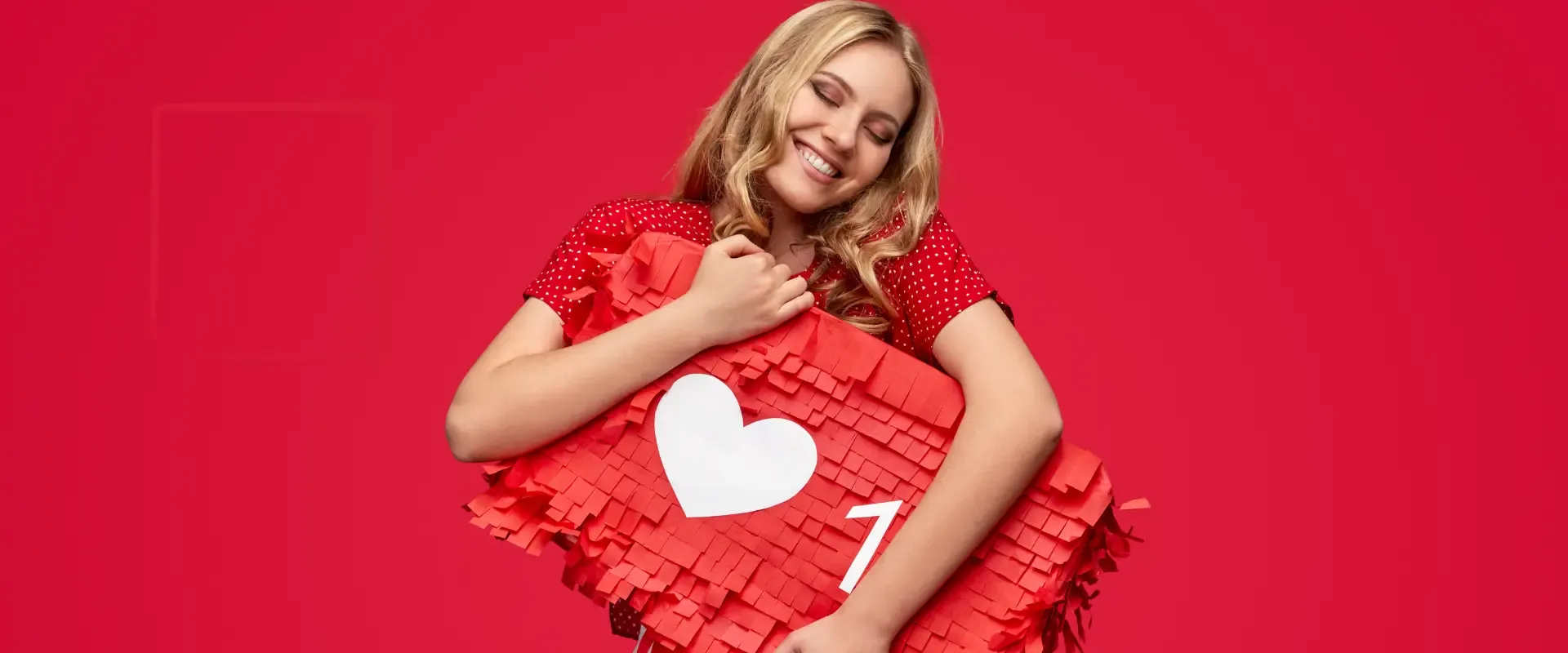 Eine lächelnde Person umarmt vor einem roten Hintergrund eine herzförmige Piñata und fängt damit die Essenz von Leidenschaft und Kreativität ein, ähnlich den dynamischen Strategien des Social Media Marketing.