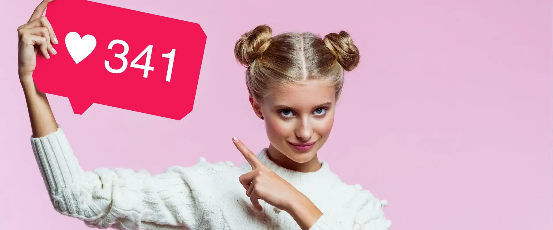 Eine Frau mit blondem Haar in zwei Dutts hält ein großes rosa Instagram-Anzeigenschild mit einem Herz und der Zahl 341 vor einem rosa Hintergrund.