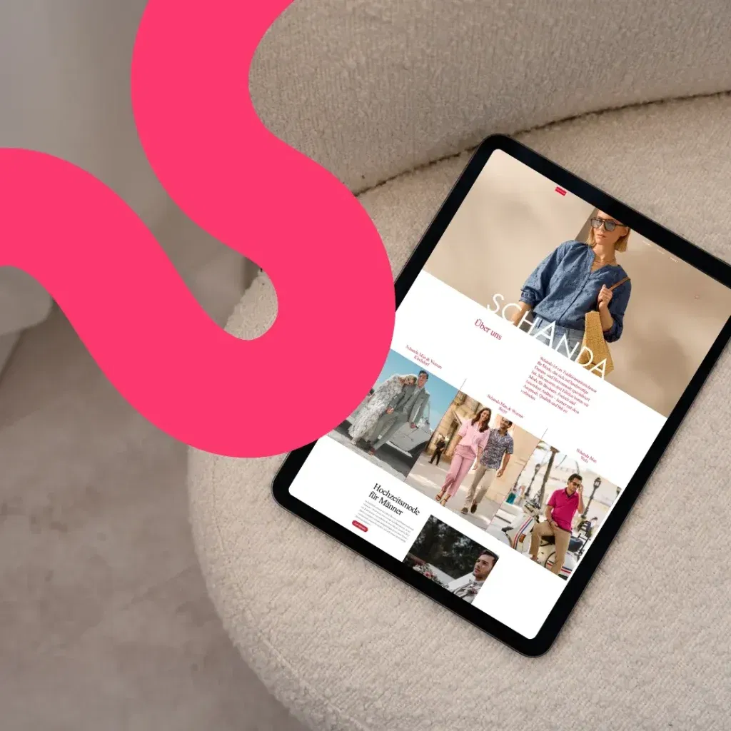 Ein Tablet, auf dem die Schanda-Mode-Website angezeigt wird, ruht auf einem beigefarbenen Polsterstuhl neben einem rosafarbenen grafischen Wirbel - perfekt für eine Fallstudie über modernes digitales Design.